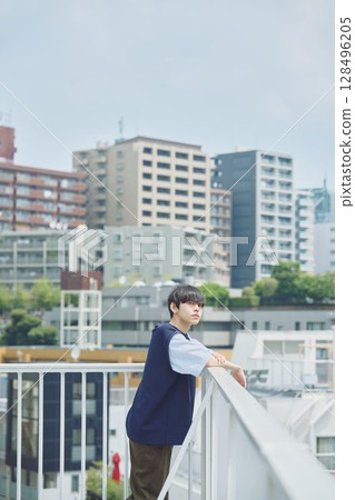 Man standing on balcony of apartment Man standing on balcony of apartment 128496205