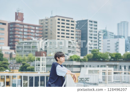 Man standing on balcony of apartment Man standing on balcony of apartment 128496207