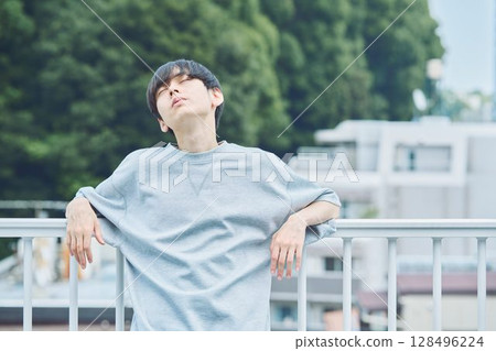 Man standing on balcony of apartment Man standing on balcony of apartment 128496224