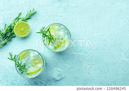 Gin tonic, overhead flat lay shot with rosemary and lime. Fresh summer cocktail Gin tonic, overhead flat lay shot with rosemary and lime. Fresh summer cocktail 128496245