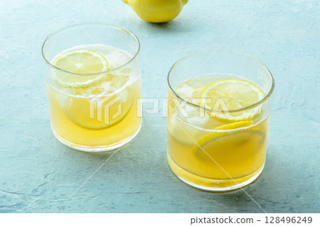 Glasses of lemonade, a mocktail with lemon juice, on a blue background Glasses of lemonade, a mocktail with lemon juice, on a blue background 128496249