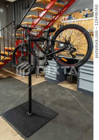 Bicycle on stand in garage prepared for mechanic work 128496368
