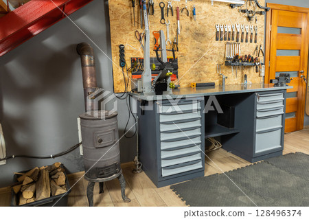 Garage interior with mechanic workspace holds neatly organized tools 128496374