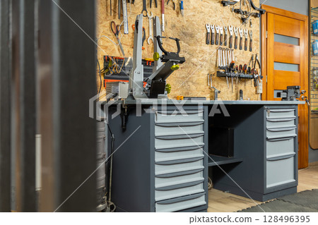 Garage interior with mechanic workspace holds neatly organized tools 128496395