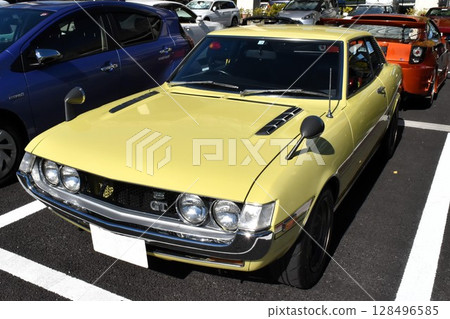Cars lined up in a parking lot (first generation Toyota Celica) 128496585