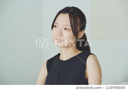 一個女人坐在床上 128496889