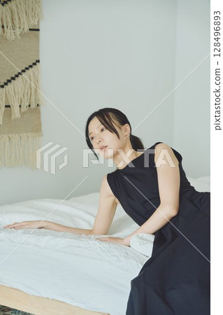 一個女人坐在床上 128496893