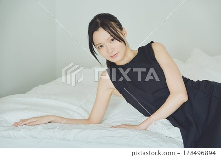 一個女人坐在床上 128496894