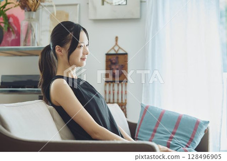 坐在客廳沙發上的女人 128496905