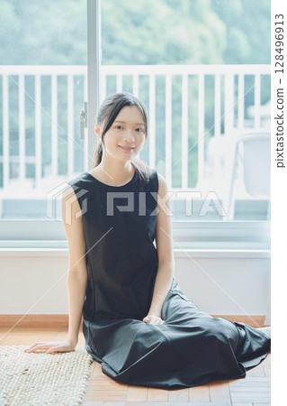 一個女人坐在窗邊 一個女人坐在窗邊 128496913