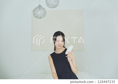 一個在床上使用智能手機的女人 128497235