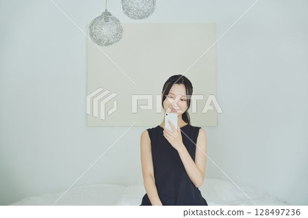 一個在床上使用智能手機的女人 128497236