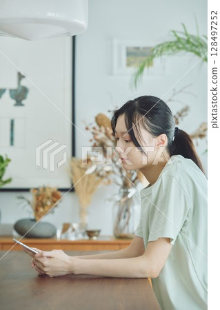 一位女士在餐廳使用智慧型手機 一位女士在餐廳使用智慧型手機 128497252