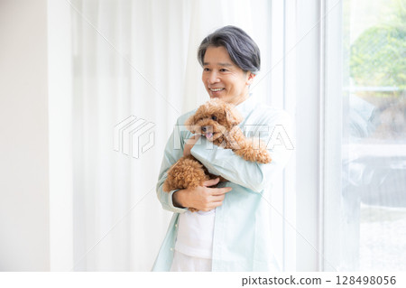 抱著玩具貴賓犬的中年男子 抱著玩具貴賓犬的中年男子 128498056
