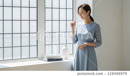 身穿淡藍色蕾絲洋裝的女子：柔和光線下靜謐的肖像 128498979