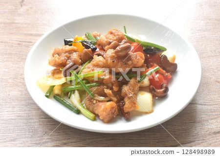 fried slice crispy chicken meat with cashew nut and bell pepper couple onion on plate  128498989