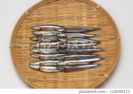 Stock photo of dried silver-striped round herring arranged in a colander - seafood 128499515