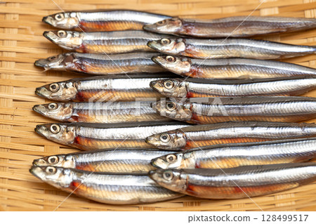 Stock photo of dried silver-striped round herring arranged in a colander - seafood 128499517