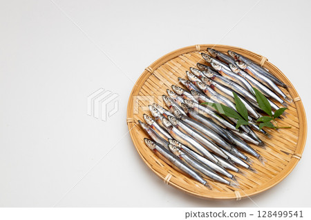 Stock photo of dried silver-striped round herring arranged in a colander - seafood Stock photo of dried silver-striped round herring arranged in a colander - seafood 128499541