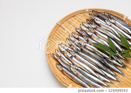 Stock photo of dried silver-striped round herring arranged in a colander - seafood Stock photo of dried silver-striped round herring arranged in a colander - seafood 128499542
