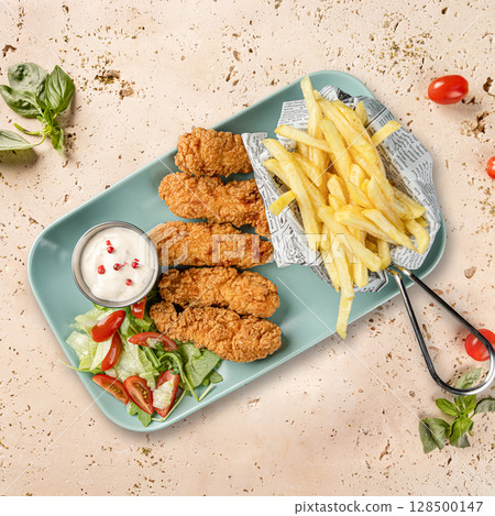 Breaded chicken strips served with french fries Breaded chicken strips served with french fries 128500147
