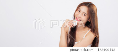 Cotton pad for gentle touch and cotton care on her skin as she removes makeup with grace, celebrating beauty and freshness in one scene. isolated studio white background 128500158