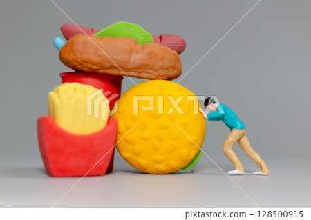 Miniature Figure Pushing Giant Fast Food Miniature Figure Pushing Giant Fast Food 128500915