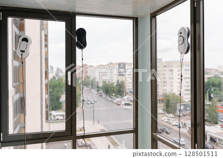 Three automatic window cleaning robots washing windows of modern apartment building, providing efficient and convenient cleaning solution for high-rise living. Concept of convenience and effectiveness Three automatic window cleaning robots washing windows of modern apartment building, providing efficient and convenient cleaning solution for high-rise living. Concept of convenience and effectiveness 128501511
