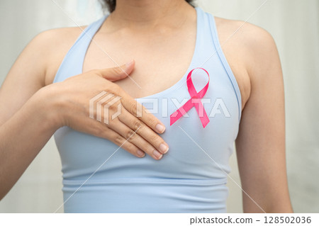 Breast cancer, pink ribbon at Asian senior lady for supporting awareness, symbol of World Breast Cancer Day. 128502036