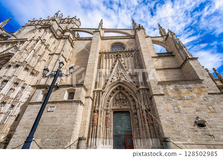Sevilla Cathedral Grand Gothic Entrance with Blue Sky Background. Sevilla Cathedral Grand Gothic Entrance with Blue Sky Background. 128502985