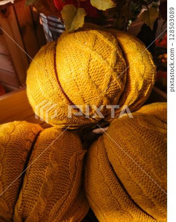 Yellow knitted pumpkins creating cozy autumn atmosphere 128503089