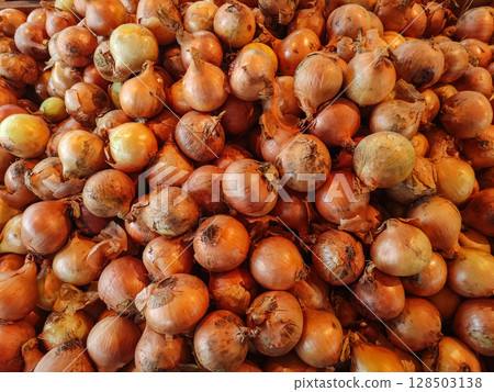 Fresh onions forming a large pile at the market 128503138