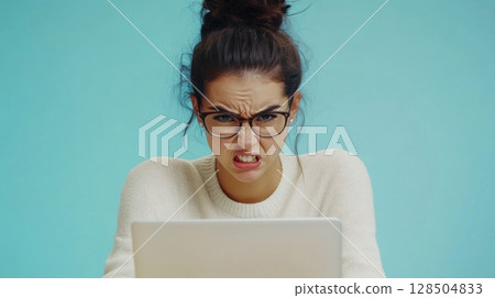frustrated woman working on laptop 128504833