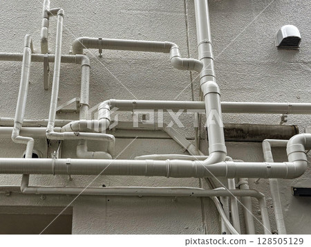 Complex piping on the exterior wall 128505129