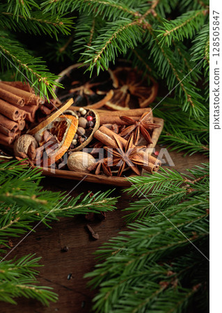 Spices and branches of Christmas tree on an old wooden table. Spices and branches of Christmas tree on an old wooden table. 128505847