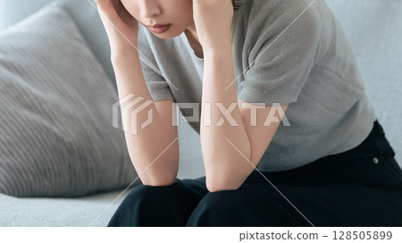 A woman holding her head in distress A woman holding her head in distress 128505899