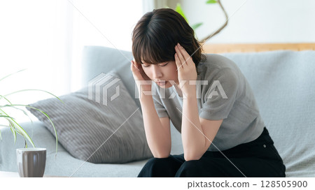 一個憂心忡忡的女人抱著頭 128505900