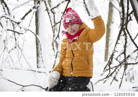 Funny little boy in colorful clothes playing outdoors during a snowfall. Active holidays with children in winter on cold snowy days. Happy child is having fun and playing in winter. Funny little boy in colorful clothes playing outdoors during a snowfall. Active holidays with children in winter on cold snowy days. Happy child is having fun and playing in winter. 128505910