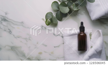 Elegant spa background, oil bottle, towel, eucalyptus on white marble, top view with space. 128506045