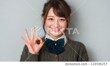 A Japanese high school girl is giving an OK sign 128506257