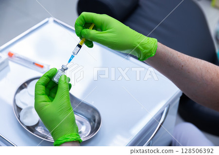 Healthcare Professional Preparing Vaccine with Syringe in Clinical Setting, Showcasing Proper Techniques and Equipment for Safe Medication Administration at Medical Facility Healthcare Professional Preparing Vaccine with Syringe in Clinical Setting, Showcasing Proper Techniques and Equipment for Safe Medication Administration at Medical Facility 128506392