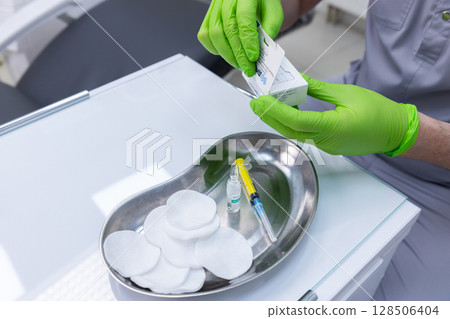 Healthcare Professional Preparing Medical Supplies for Procedure with Gloves and Sterile Equipment in a Clinical Setting Focused on Patient Safety and Hygiene Protocols Healthcare Professional Preparing Medical Supplies for Procedure with Gloves and Sterile Equipment in a Clinical Setting Focused on Patient Safety and Hygiene Protocols 128506404