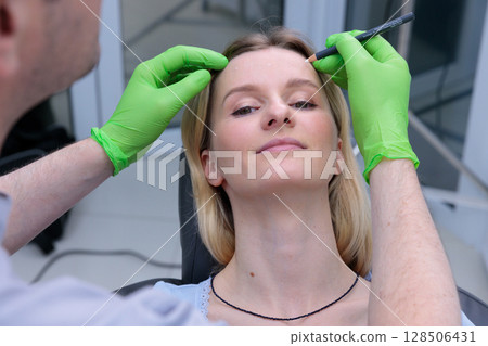 A Patient Prep for a Cosmetic Procedure: Exploring the Delicate Balance of Aesthetics and Medical Precision in a Contemporary Clinic Setting, Showcasing Professionalism and Care 128506431