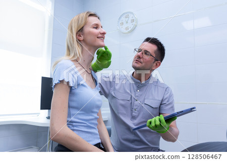 Professional Dentist Consultation for Careful Evaluation of Patient's Facial Features in a Bright and Modern Dental Clinic Setting with Warm Interactions Professional Dentist Consultation for Careful Evaluation of Patient's Facial Features in a Bright and Modern Dental Clinic Setting with Warm Interactions 128506467