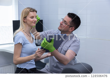 A Professional Consultation in a Modern Aesthetic Clinic: Expert Assessing Client's Facial Features and Skin Health with Tablet for Personalized Treatment Planning 128506476