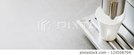 Close-up of white coffee cup on coffee machine on grey marble background. Natural light. Professional coffee brewing. Coffee break. Good morning Close-up of white coffee cup on coffee machine on grey marble background. Natural light. Professional coffee brewing. Coffee break. Good morning 128506704