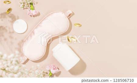 Self care flat lay with mask for sleep, sleeping gel capsules or vitamins or dietary supplements and flowers. Concept of healthy sleep and no depression. Natural remedies for relax. Copy space 128506710