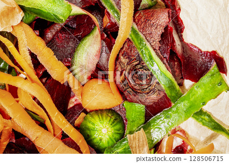Vegetable scraps ready for composting. Vegetable peelings on wrapping paper on white kitchen table set aside for compost. Concept of processing organic waste for fertilize soil. Flat lay, close up 128506715