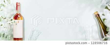 Banner for wine shop, wine bar winery or wine delivery. Mockup of bottles of champaign and rose wine with glasses on light blue background with leaves and shadows. Banner size, flat lay, copy space 128506716