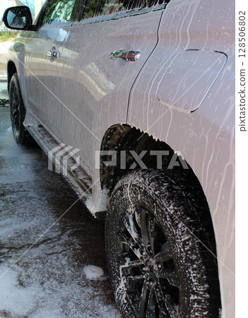 Vehicle After Off Road Driving  Is Treated With Cleaning Foam At A Car Wash 128506802